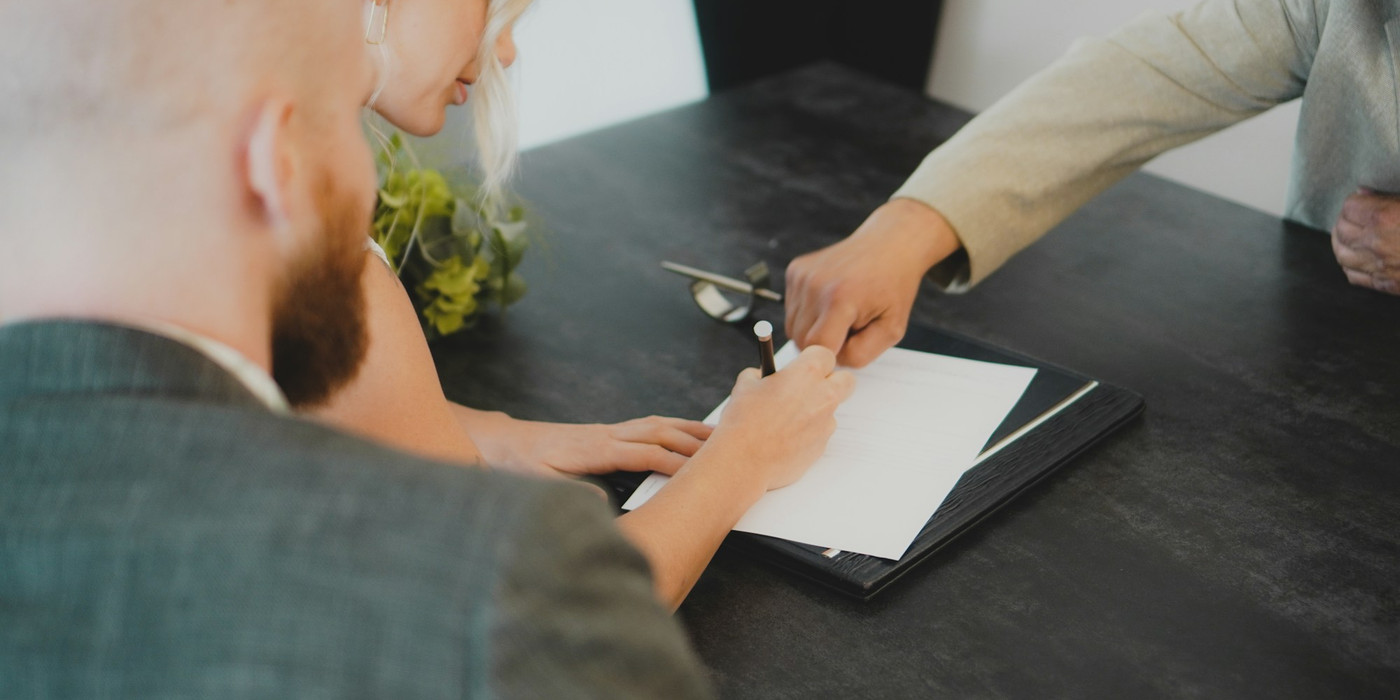 Renters signing paperwork to change the names on a lease